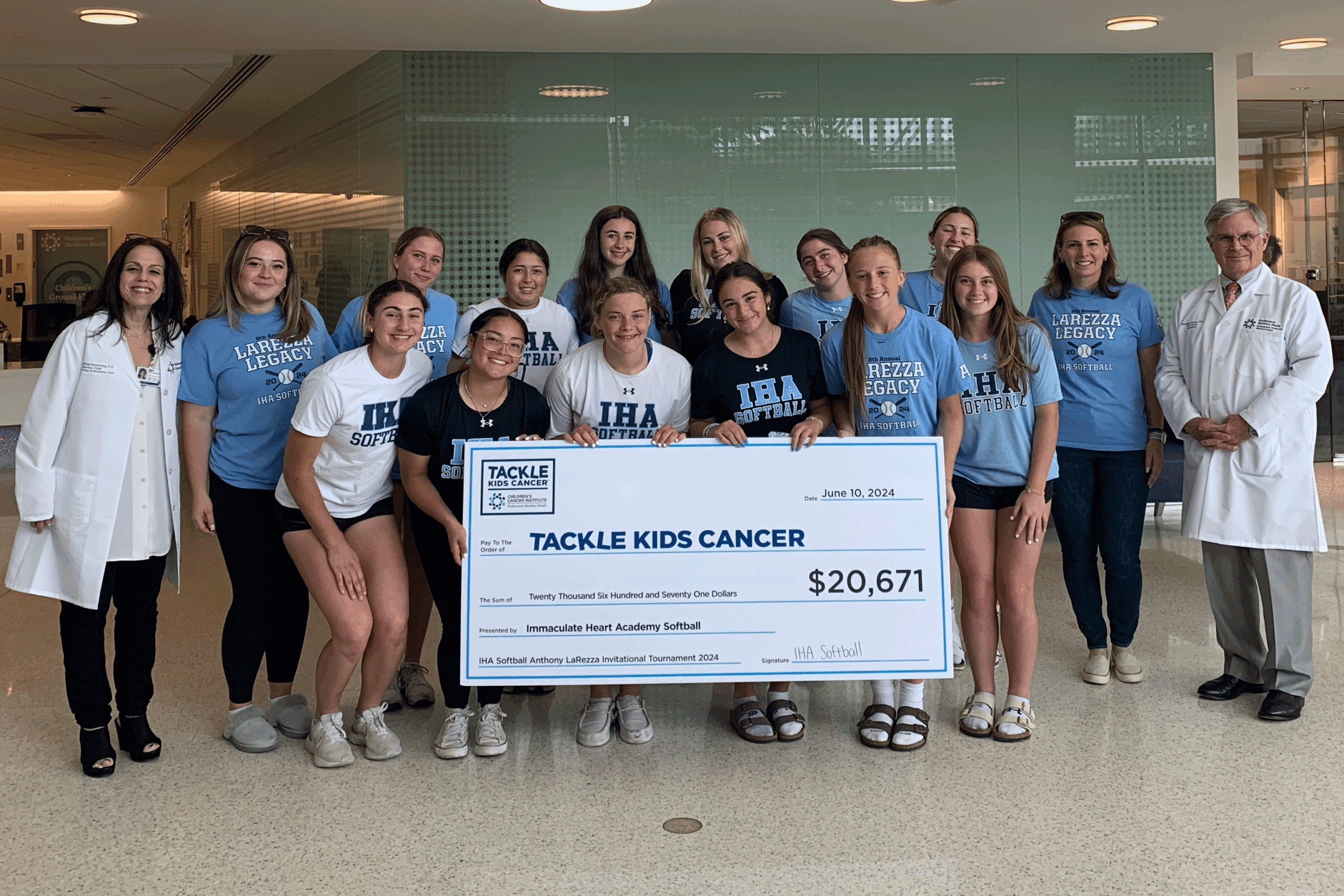 IHA Softball Team check presentation to Tackle Kids Cancer